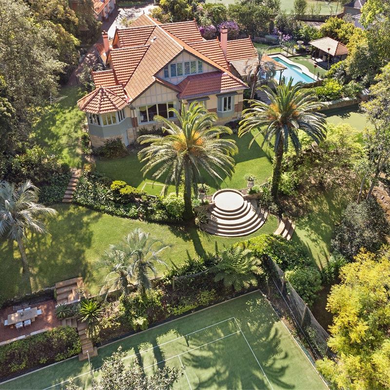 Aerial view of a grand estate with gardens, pool and tennis court