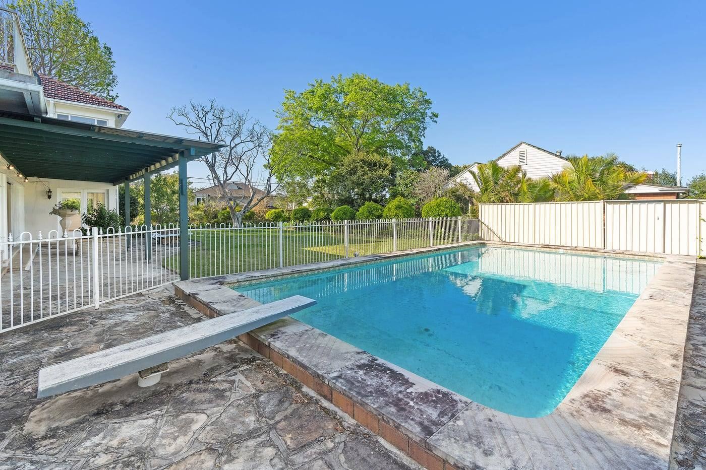 Swimming pool and patio with leafy outlook